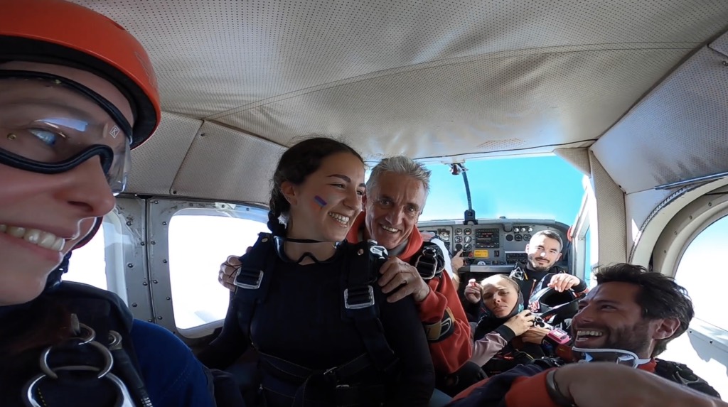 Groupe souriant dans l’avion avant le saut